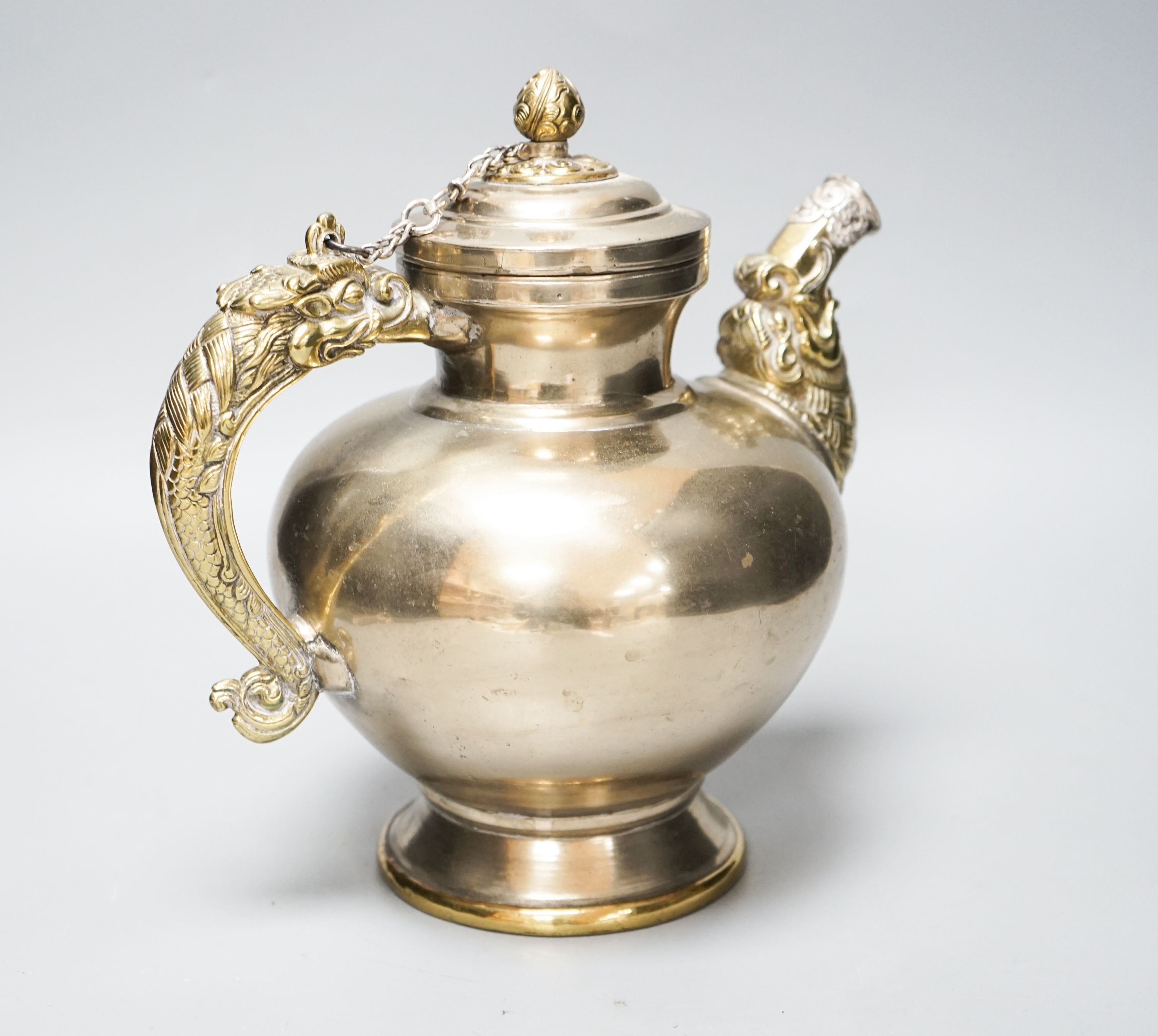 A late 19th/early 20th century Tibetan paktong, bronze and silver mounted teapot, 24cm